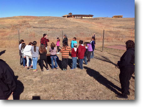 Tyler teaching the students. Their bus in the background.